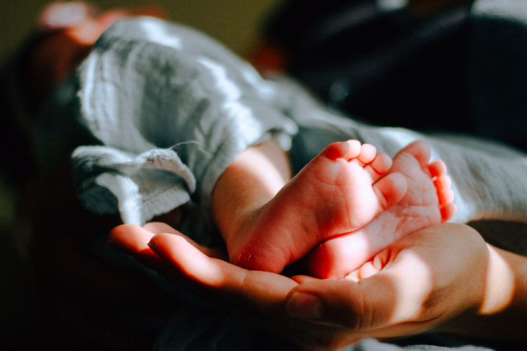 piedini di neonato in una mano