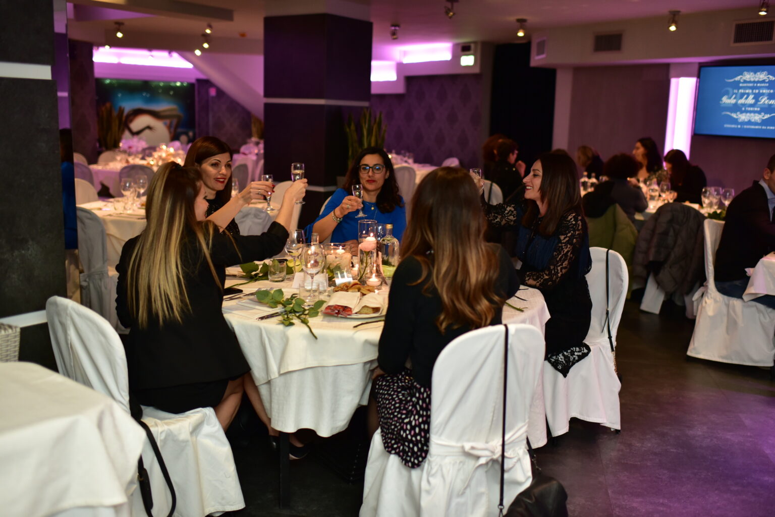 Signore al tavolo sala party experience che brindano