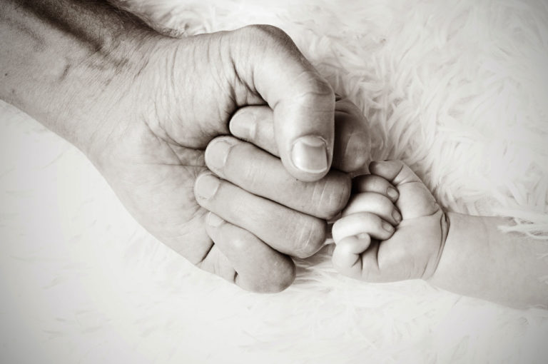 mano di adulto e manina di bambino